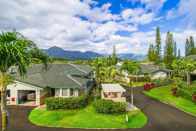 view of front of house with a garage, a mountain view, and a front yard