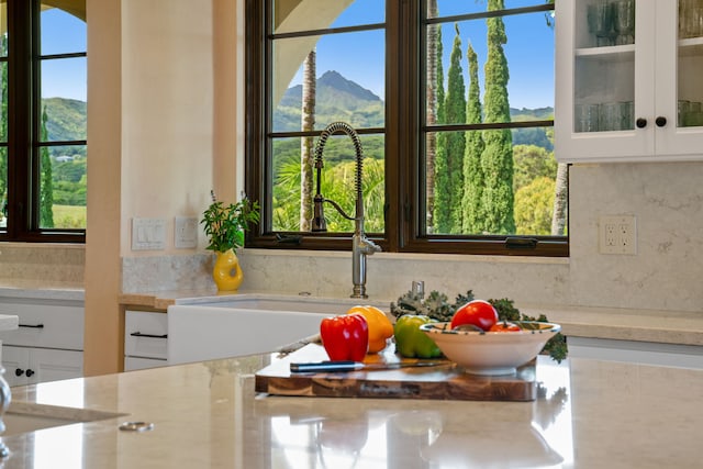 interior space featuring white cabinets, a mountain view, and sink