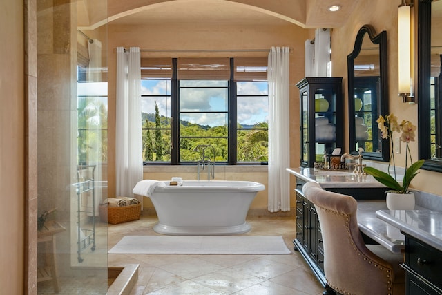 bathroom featuring vanity, a walk in shower, and a freestanding bath