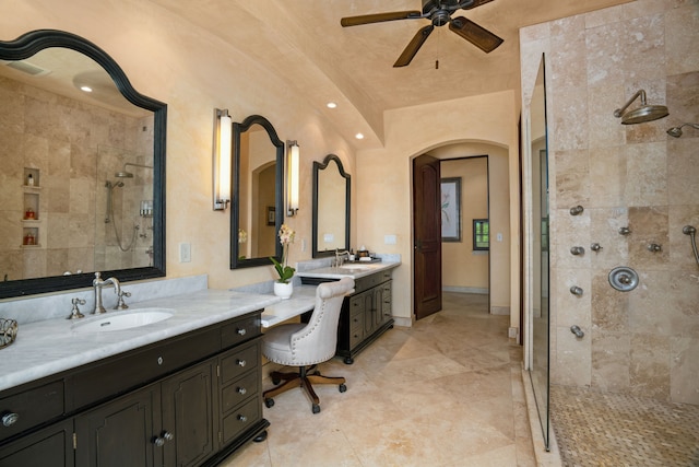 full bathroom featuring a tile shower, vanity, and ceiling fan