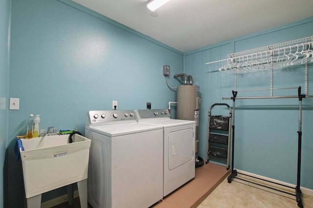 washroom with a textured ceiling, washer and clothes dryer, sink, and water heater