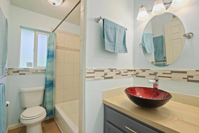 full bathroom with toilet, tiled shower / bath, vanity, backsplash, and tile walls