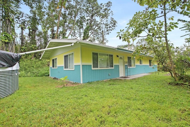 rear view of house featuring a lawn and a porch