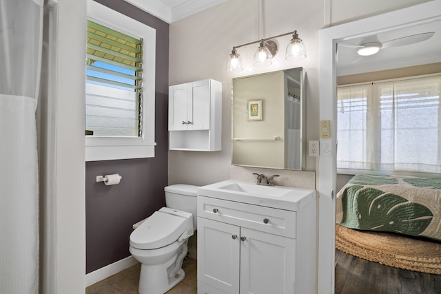 bathroom featuring toilet, a healthy amount of sunlight, ornamental molding, and vanity