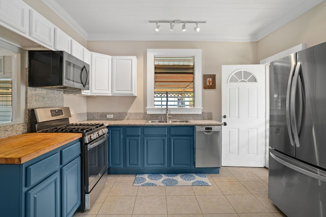 kitchen with blue cabinetry, white cabinetry, appliances with stainless steel finishes, sink, and rail lighting