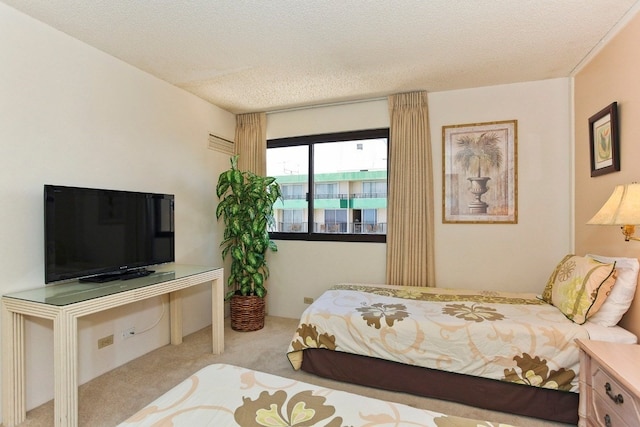 bedroom featuring a textured ceiling and light carpet