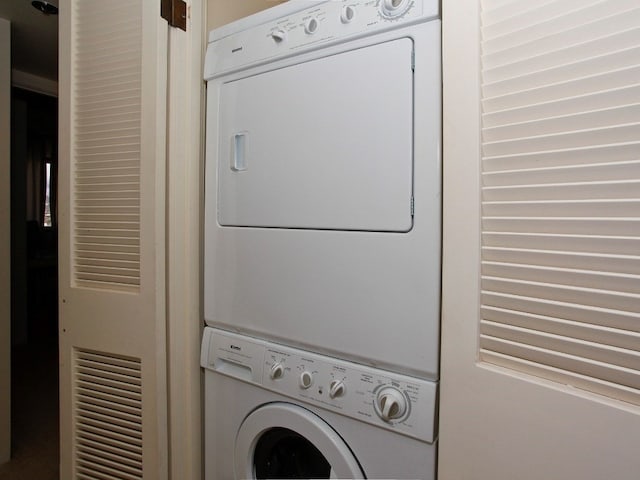 clothes washing area featuring stacked washer / dryer