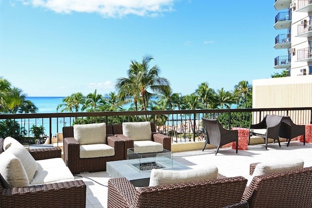 exterior space featuring a balcony, an outdoor living space, and a water view