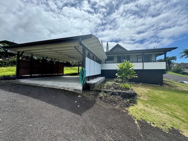 view of parking with a lawn and a carport