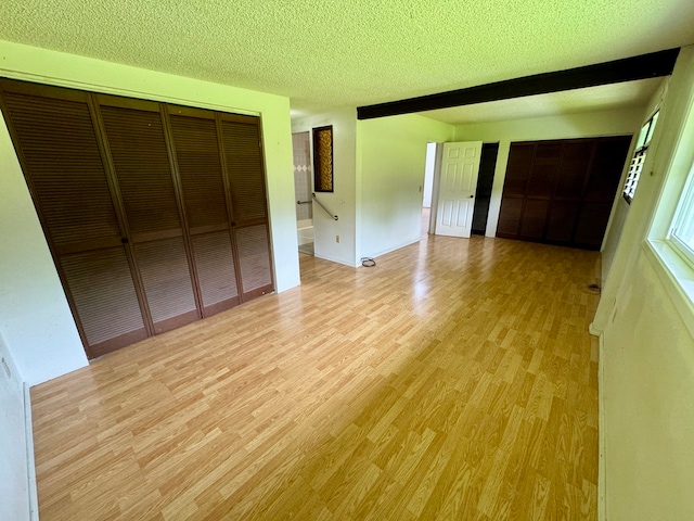 unfurnished bedroom featuring a textured ceiling, light hardwood / wood-style flooring, and a closet