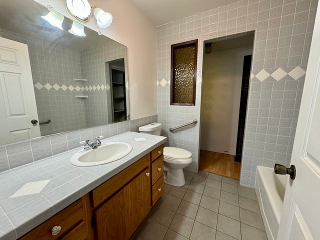 bathroom with tile walls, tile patterned flooring, vanity, and toilet