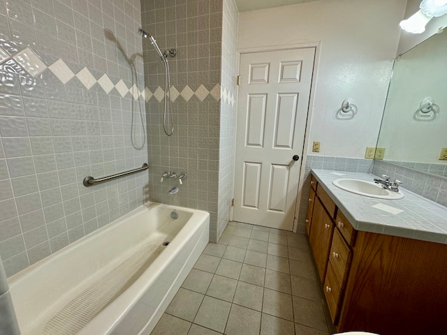 bathroom with tiled shower / bath, vanity, and tile patterned flooring