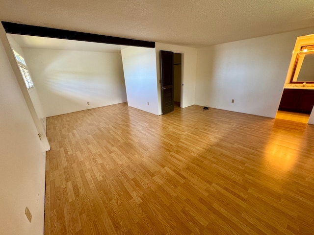 unfurnished room with wood-type flooring and a textured ceiling