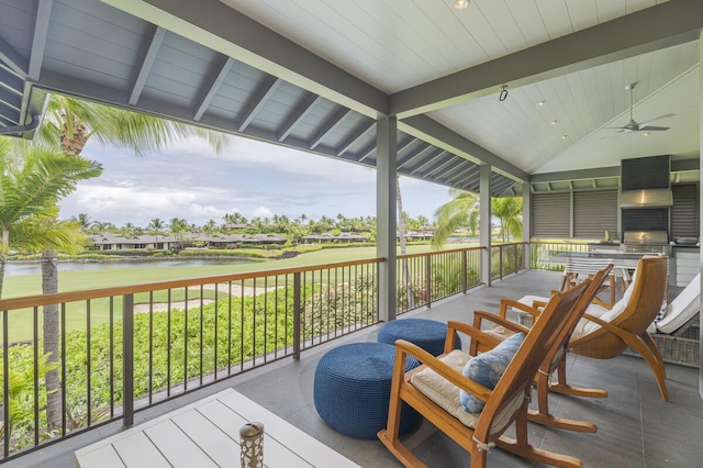 deck with area for grilling, a ceiling fan, and a water view