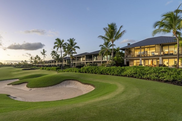 view of property's community featuring a yard and view of golf course