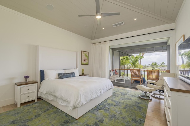 bedroom with visible vents, baseboards, vaulted ceiling, wood finished floors, and access to outside