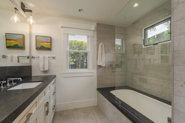 bathroom featuring recessed lighting, a healthy amount of sunlight, vanity, and baseboards