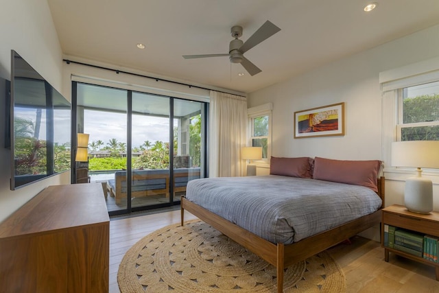 bedroom featuring access to exterior, multiple windows, and light wood-type flooring