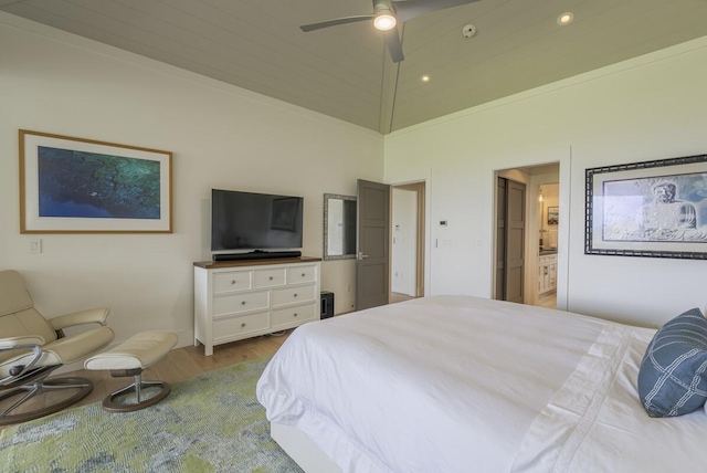 bedroom with connected bathroom, wood finished floors, and a ceiling fan