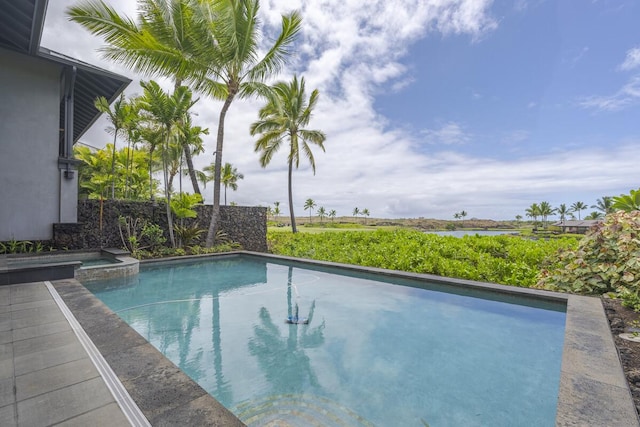 view of pool with a water view and a pool with connected hot tub