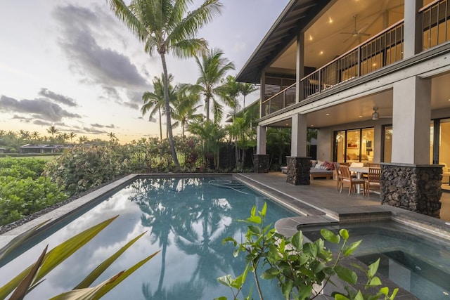 pool with an in ground hot tub, a patio area, and ceiling fan