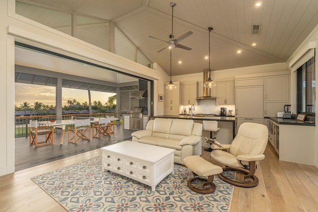 living area featuring light wood finished floors, visible vents, ceiling fan, wood ceiling, and high vaulted ceiling