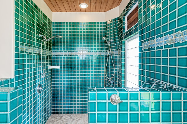 bathroom with wood ceiling, tile walls, and tiled shower