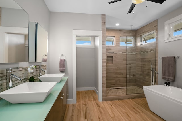 bathroom featuring vanity, hardwood / wood-style floors, tasteful backsplash, ceiling fan, and independent shower and bath