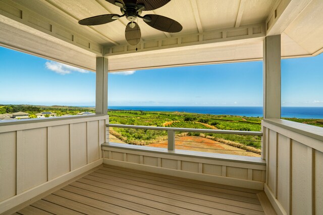 balcony featuring ceiling fan and a water view