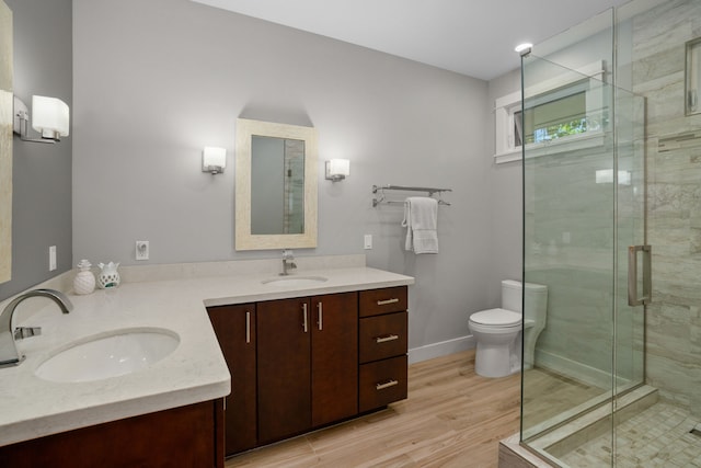 bathroom featuring vanity, toilet, wood-type flooring, and walk in shower