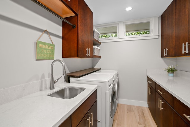 laundry room with independent washer and dryer, light hardwood / wood-style floors, cabinets, and sink