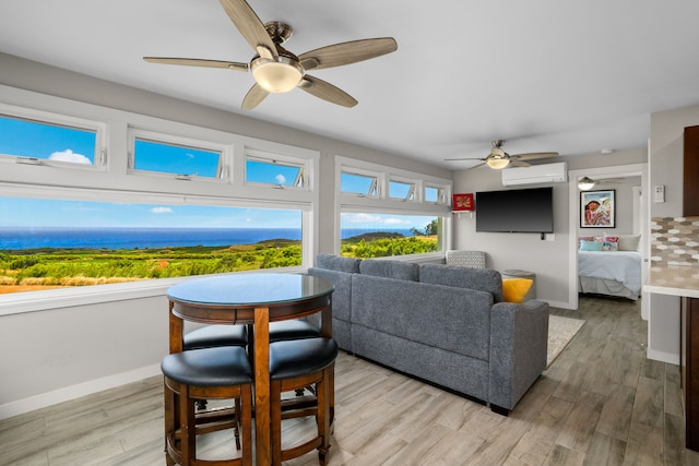 living room with light wood-type flooring, a wall unit AC, and ceiling fan