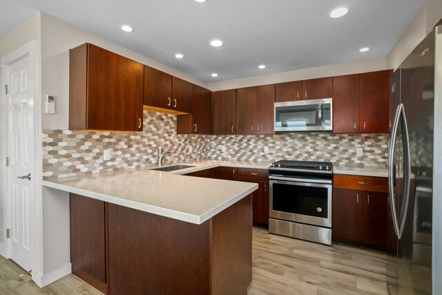 kitchen featuring backsplash, kitchen peninsula, sink, ceiling fan, and dark brown cabinetry