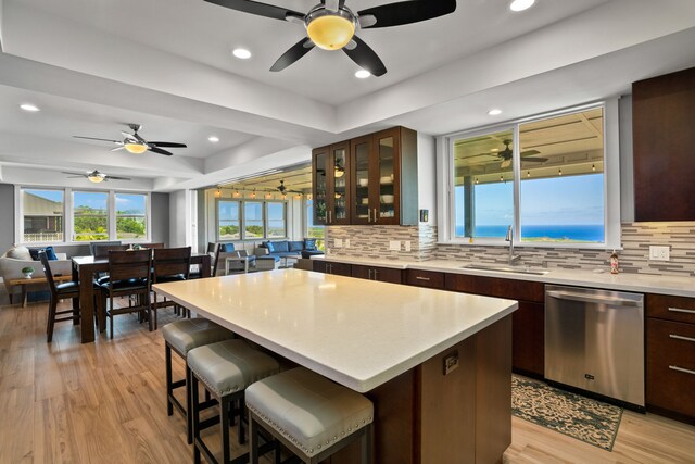 kitchen with dishwasher, sink, a center island, and ceiling fan