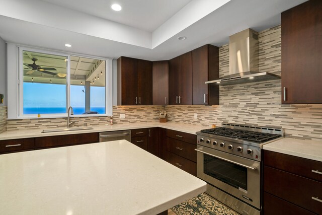 kitchen featuring sink, dark brown cabinetry, appliances with stainless steel finishes, and wall chimney exhaust hood