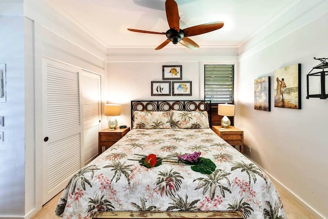 carpeted bedroom featuring ceiling fan, a closet, and ornamental molding