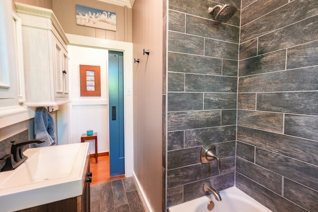 bathroom featuring tiled shower / bath, hardwood / wood-style floors, and sink