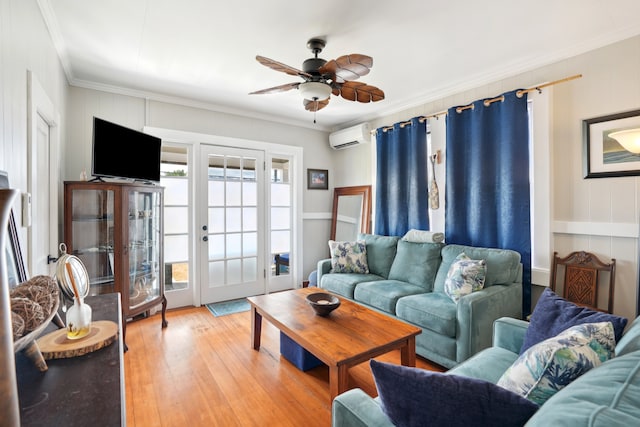 living room featuring a wall mounted AC, ornamental molding, ceiling fan, and light hardwood / wood-style floors