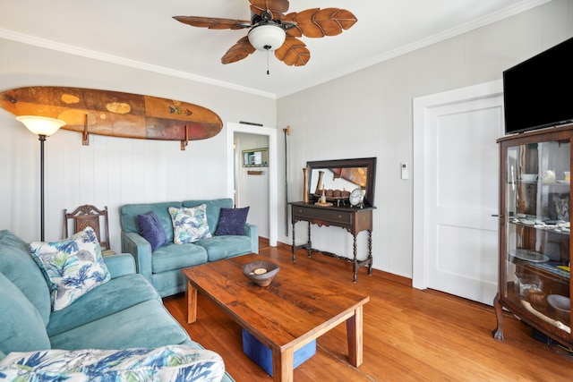 living room with ceiling fan, ornamental molding, and light hardwood / wood-style flooring