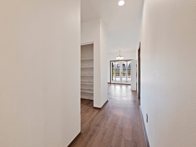 hallway featuring a notable chandelier and dark hardwood / wood-style flooring