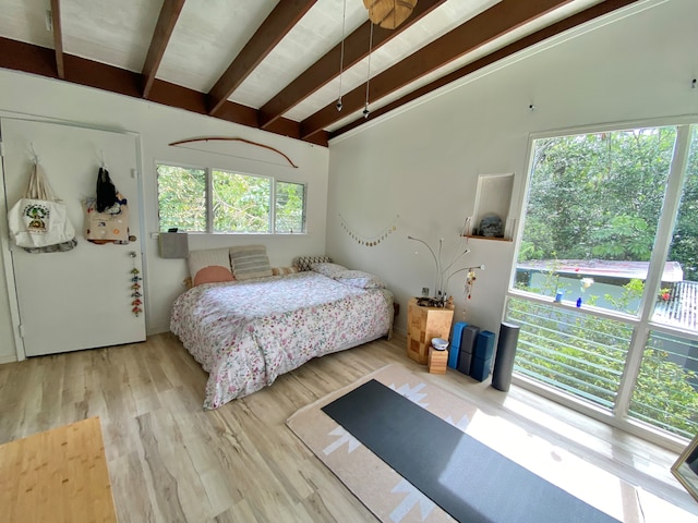 bedroom with light wood-type flooring and lofted ceiling with beams