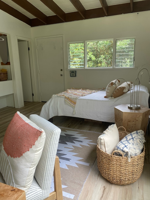 bedroom with hardwood / wood-style flooring and beam ceiling