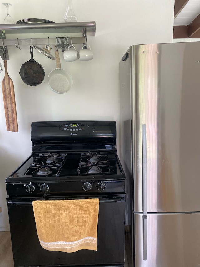 kitchen with stainless steel fridge and black gas range