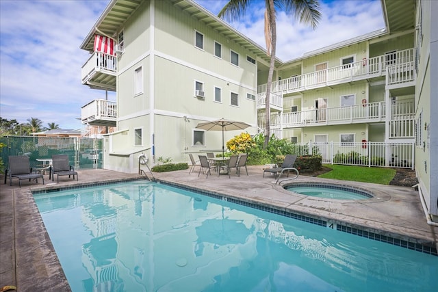 view of swimming pool featuring a community hot tub and a patio