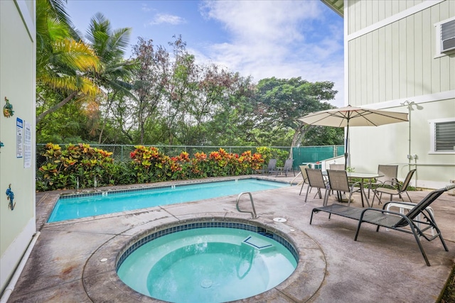 view of swimming pool with a hot tub and a patio area