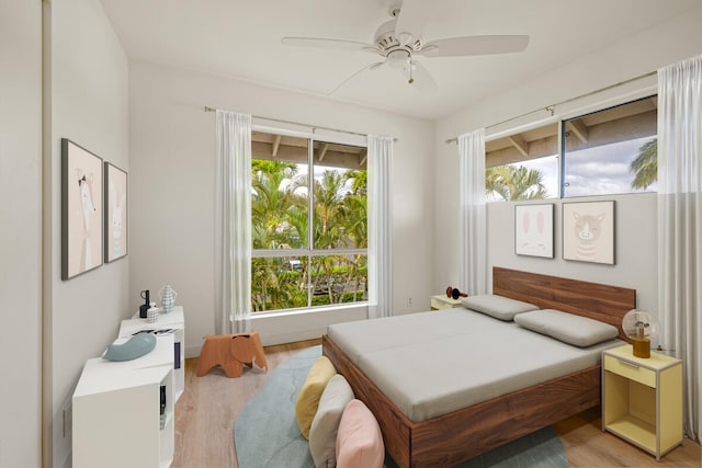 bedroom with light hardwood / wood-style floors, multiple windows, and ceiling fan