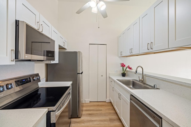 kitchen featuring white cabinetry, sink, light hardwood / wood-style flooring, and appliances with stainless steel finishes