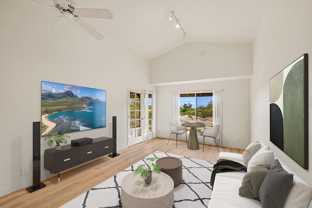 living room featuring ceiling fan, light hardwood / wood-style flooring, rail lighting, and high vaulted ceiling