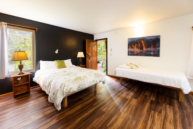 bedroom with dark hardwood / wood-style flooring and multiple windows