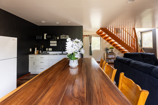 dining area with wet bar and dark wood-type flooring